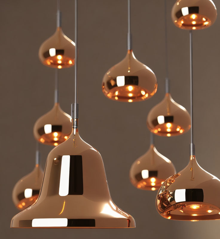 Cluster of Modern Copper Pendant Lights Emitting Warm Glow on Muted Brown Background