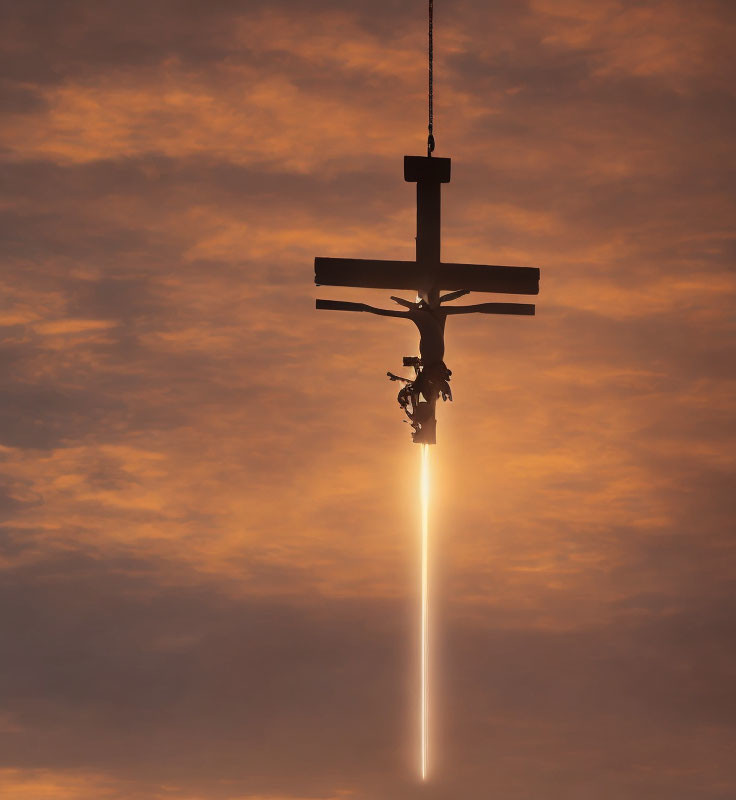 Silhouette of crucifix and figure under cloudy sunset sky with vertical light ray