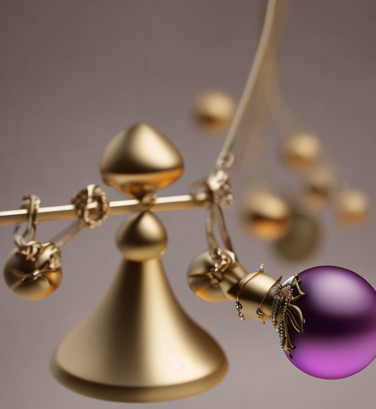 Brass-toned geometric mobile with purple sphere and intricate details