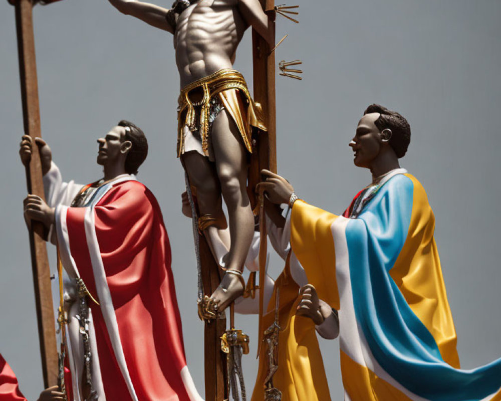 Religious statues of crucifixion with two figures against clear sky