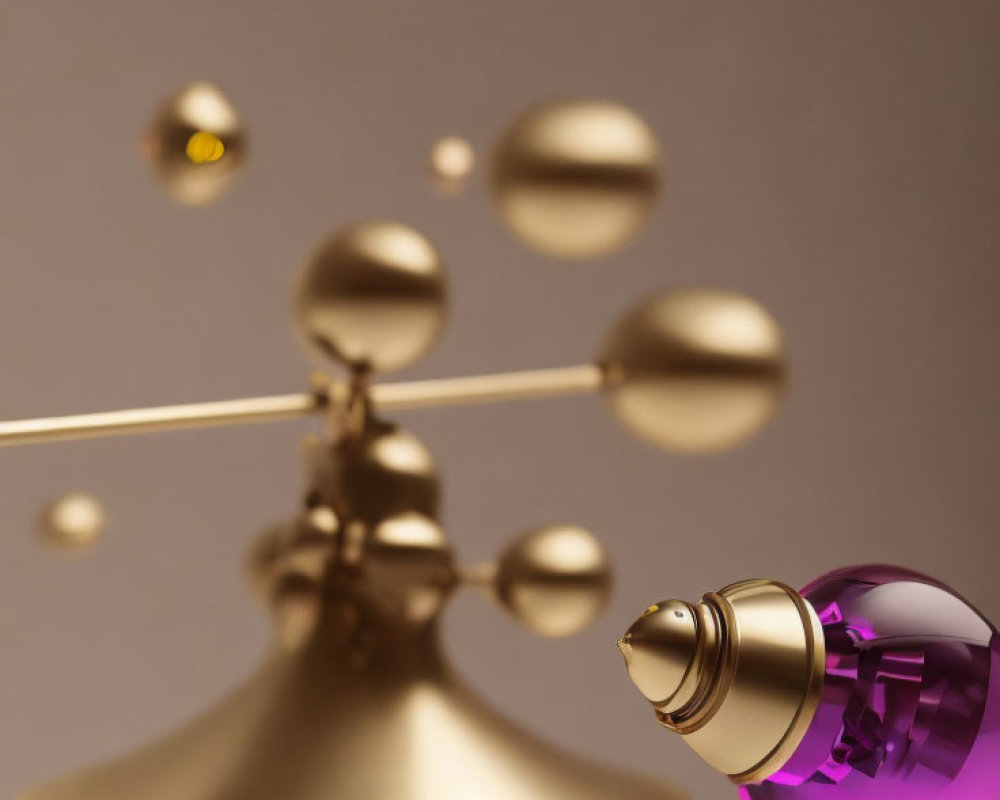 Golden Mobile Sculpture with Spherical Elements and Purple Glass Perfume Bottle