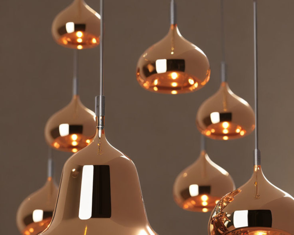 Cluster of Modern Copper Pendant Lights Emitting Warm Glow on Muted Brown Background