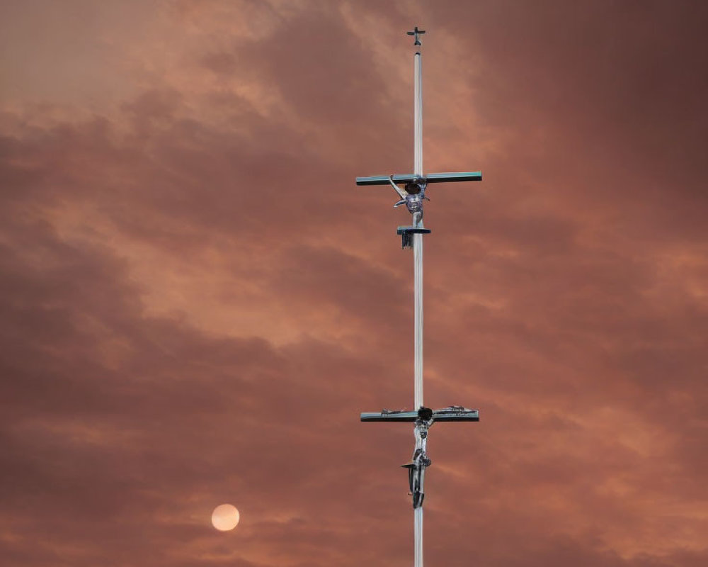 Tall Cross with Multiple Bars in Orange-Clouded Sky