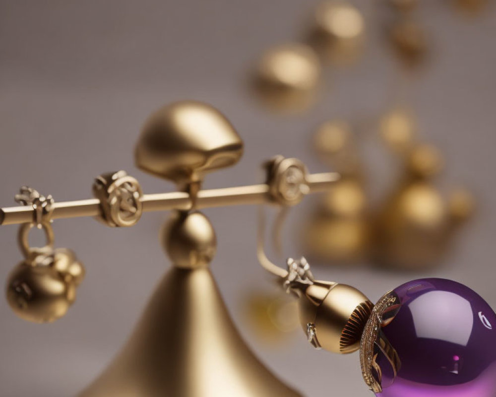 Golden perpetual motion desk toy with purple sphere in focus