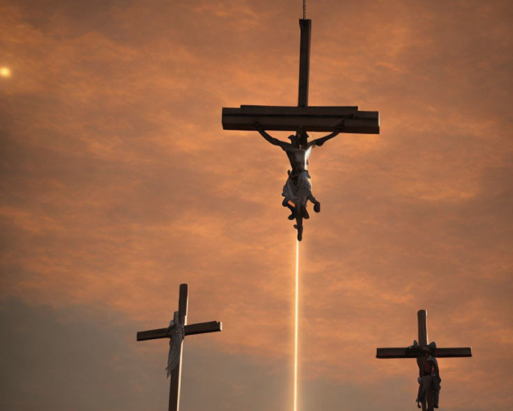 Three Crosses Silhouetted in Orange Sky with Central Cross Illuminated