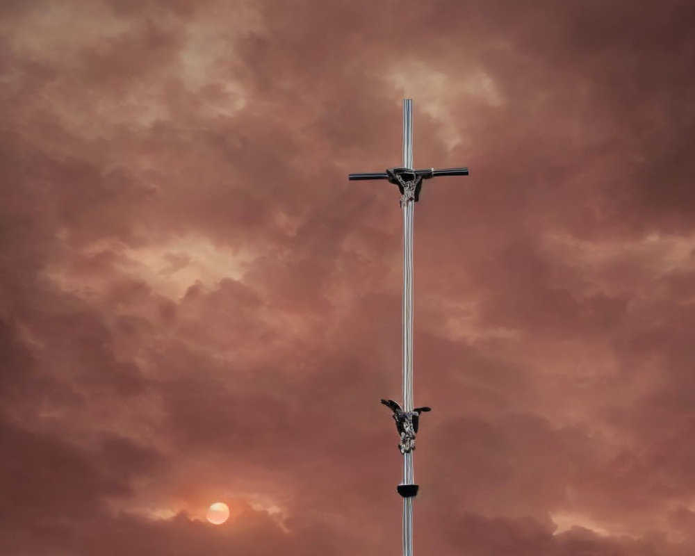 Silhouetted Crucifix Against Orange Sunset Sky