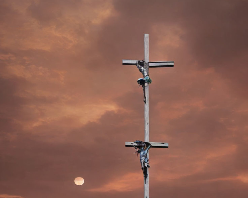 Cross and figures under orange sky with moon and bird.