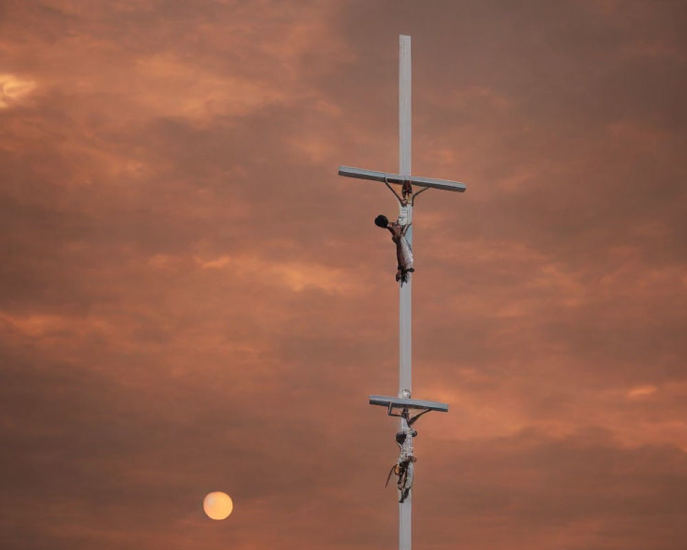 Crucifix Silhouetted Against Fiery Sunset Sky