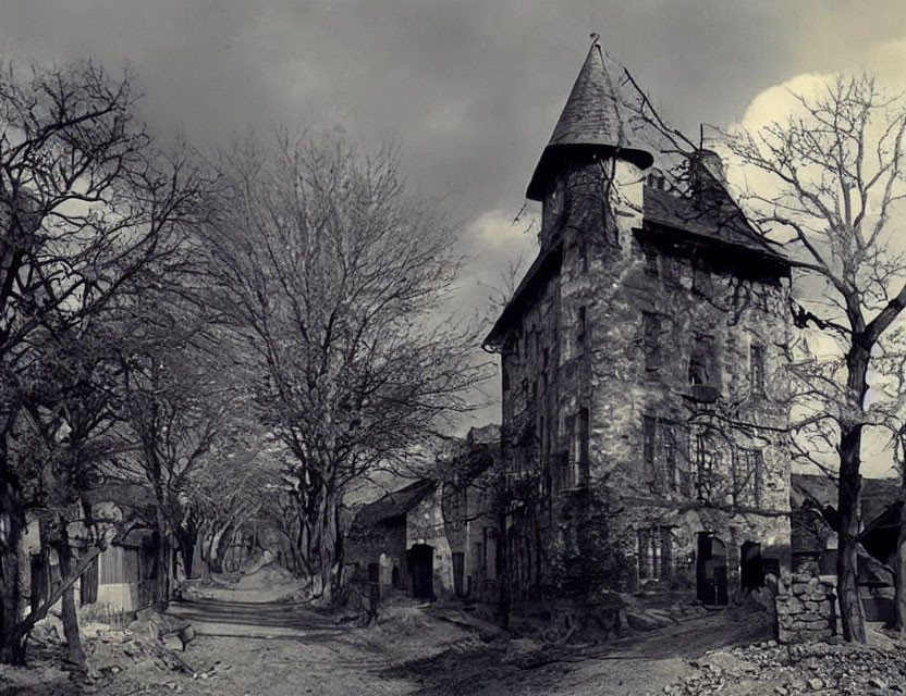 Vintage black and white photo of desolate street with bare trees and aged stone building