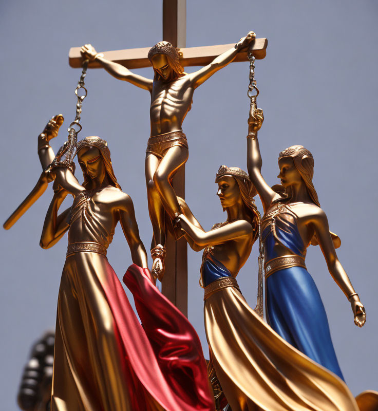 Four Women Statues Holding Cross with Jesus Christ Figure Under Clear Sky