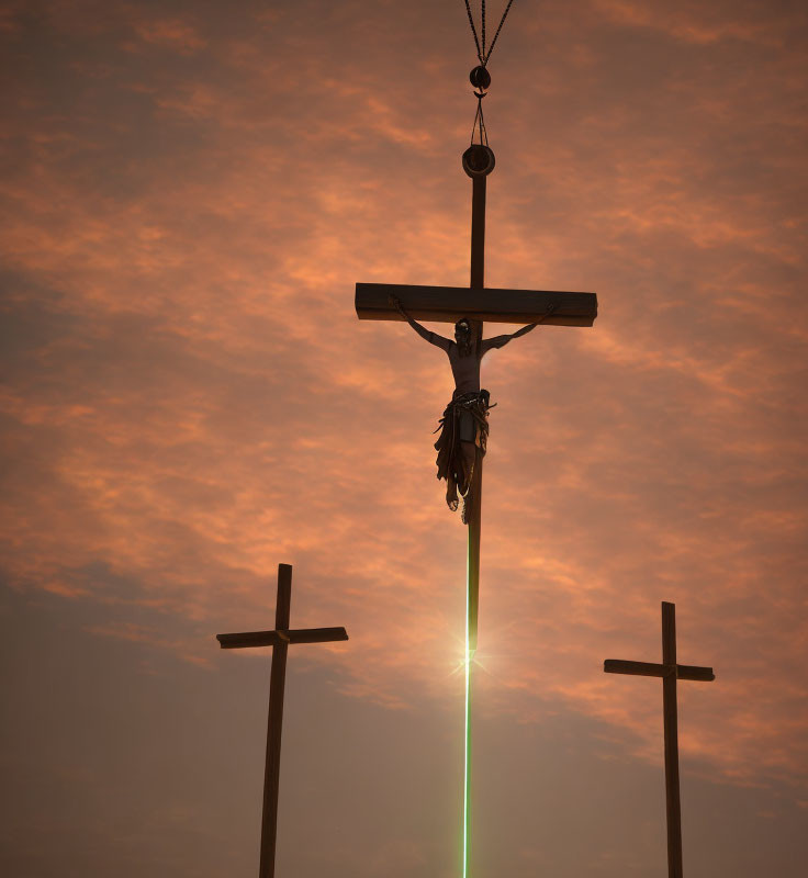 Silhouetted crosses against orange sky with central figure.