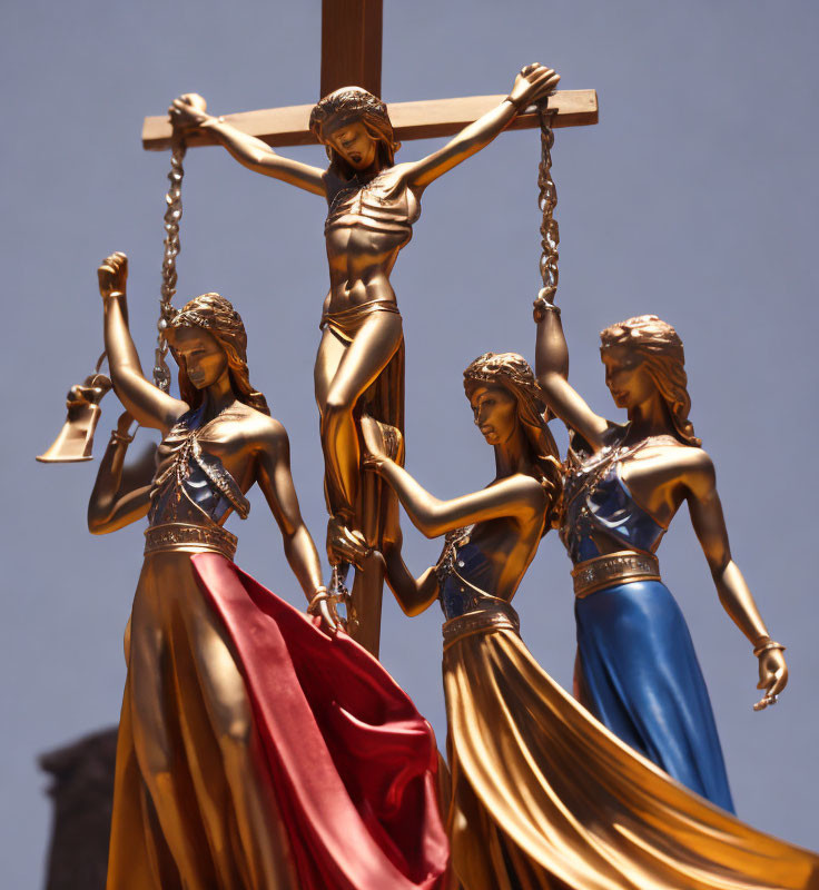 Four Metallic Lady Justice Statues Surround Central Crucifix under Clear Sky