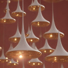 White and Gold Pendant Lights Emitting Warm Glow on Red Background