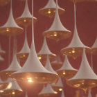 Inverted teardrop-shaped modern lighting fixtures on red ceiling