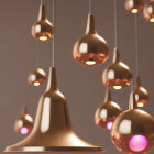 Modern Copper Pendant Lights with Glossy Finish and Soft Pink Glow Against Muted Background