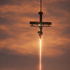 Silhouette of crucifix and figure under cloudy sunset sky with vertical light ray