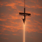 Silhouette of Crucifix with Jesus in Fiery Sky & Beam of Light