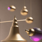 Abstract composition featuring bronze bell, suspended orbs, purple lights, and reflective surfaces