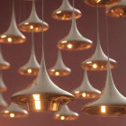 Sleek teardrop pendant lights emit warm glow in red ambiance