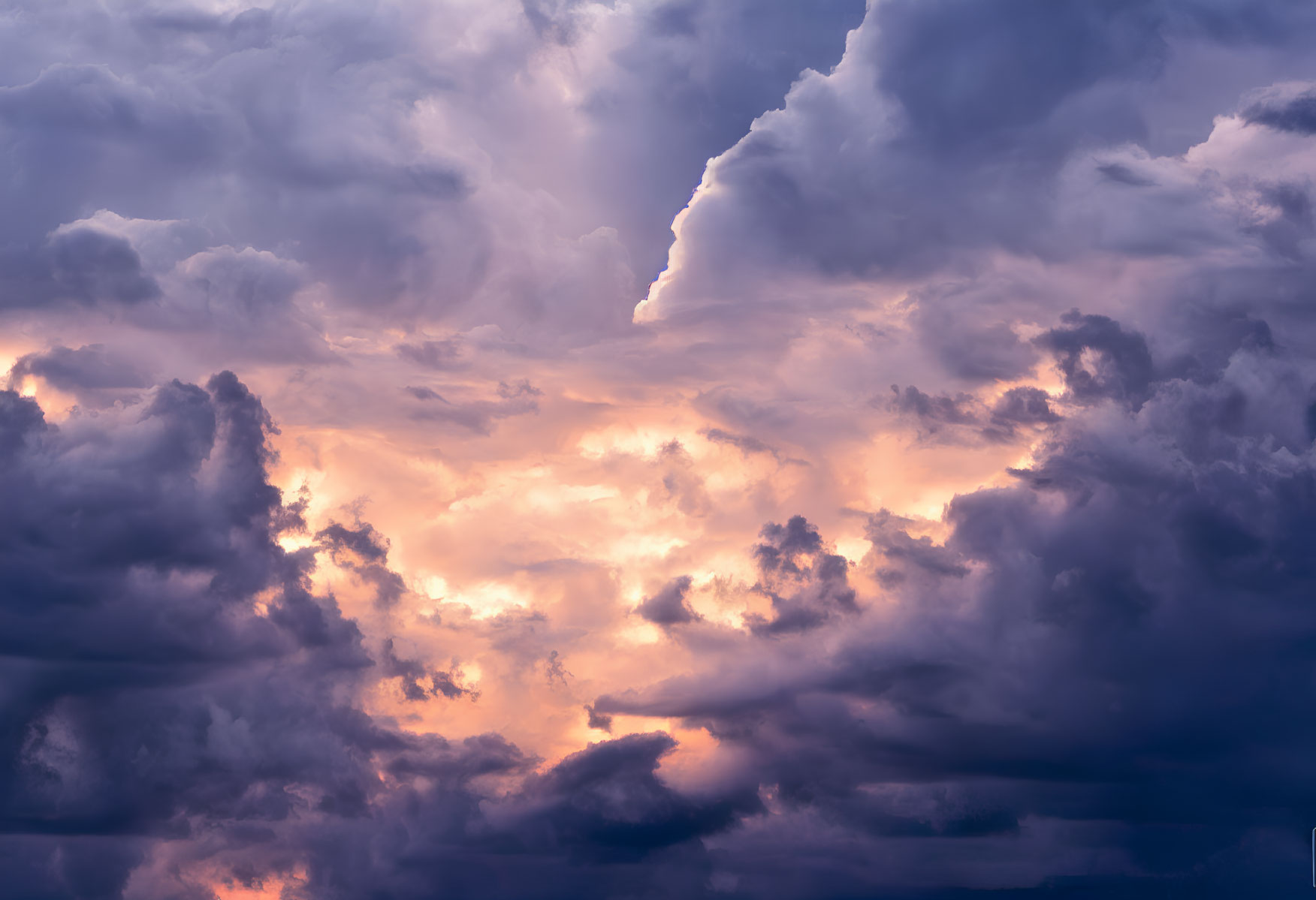 Dramatic sky with billowing clouds in purple, blue, and orange.