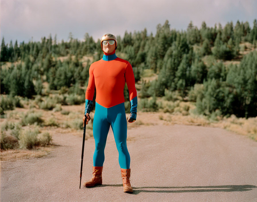 Superhero in Red and Blue Costume with Gold Helmet and Goggles on Road