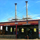 Vibrant corner building with "CHILEGAS" sign under blue sky