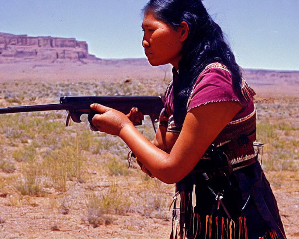 Traditional attire woman aiming rifle in desert with mesa.