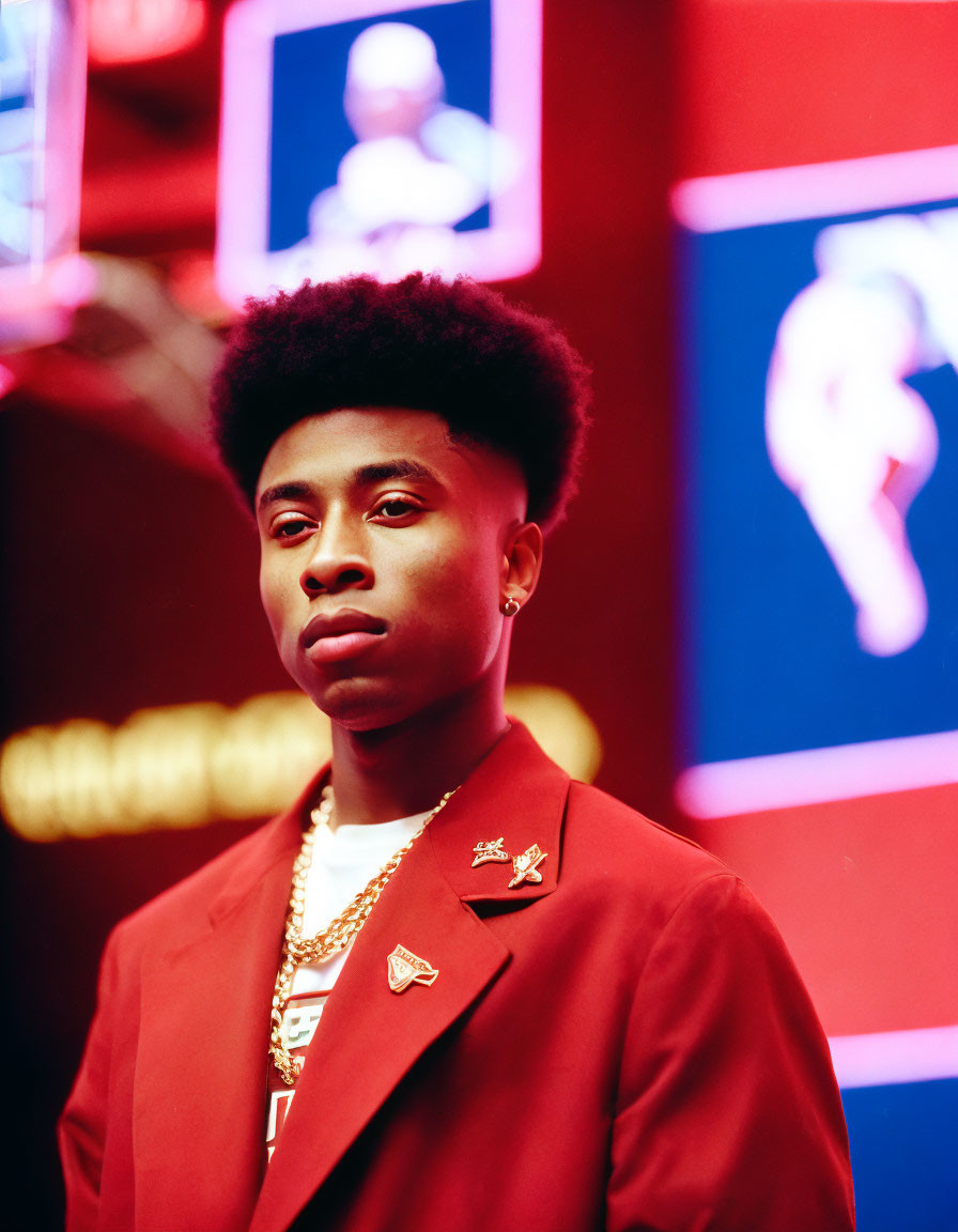 Confident individual in red blazer with pins against neon-lit background