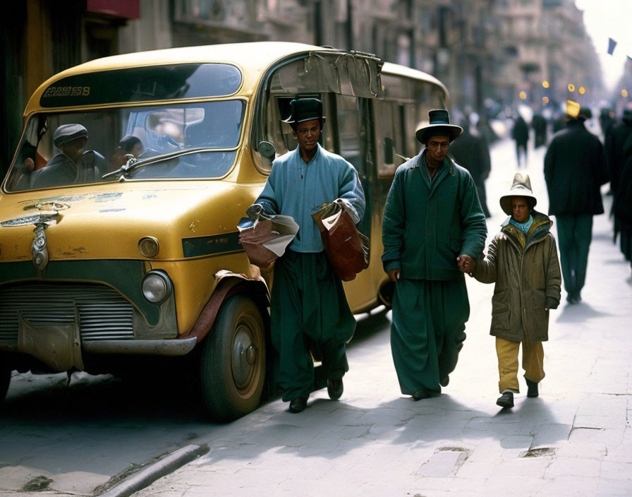 Three individuals walking next to a vintage yellow bus on a city street, featuring traditional attire and a child