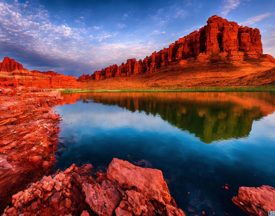 Tranquil river at sunset with red rock formations reflected in water