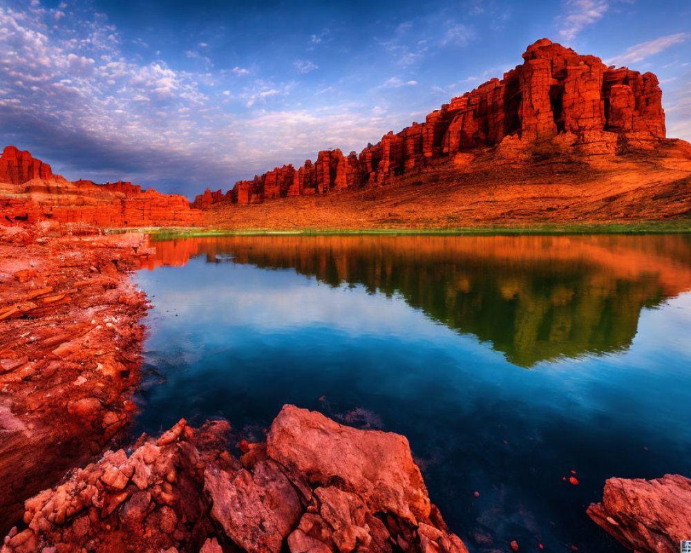 Tranquil river at sunset with red rock formations reflected in water