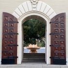 Weathered wooden doors open to courtyard with fountain