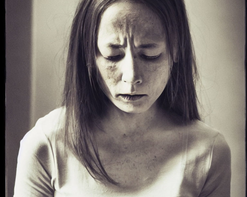 Melancholic young woman with freckles in monochromatic photo