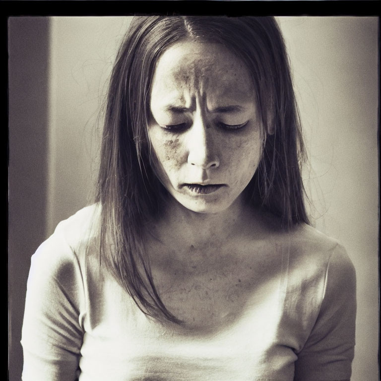 Melancholic young woman with freckles in monochromatic photo