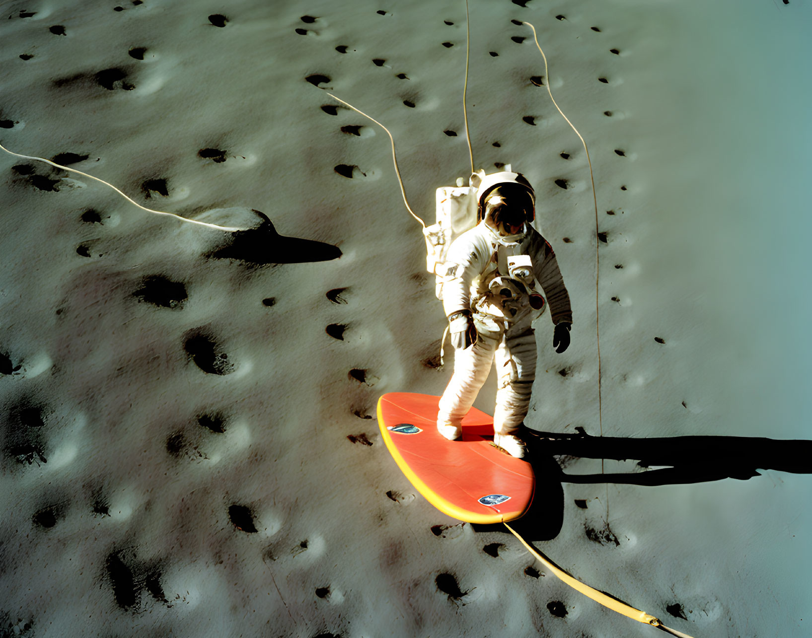 Astronaut in spacesuit on red surfboard in moon-like landscape