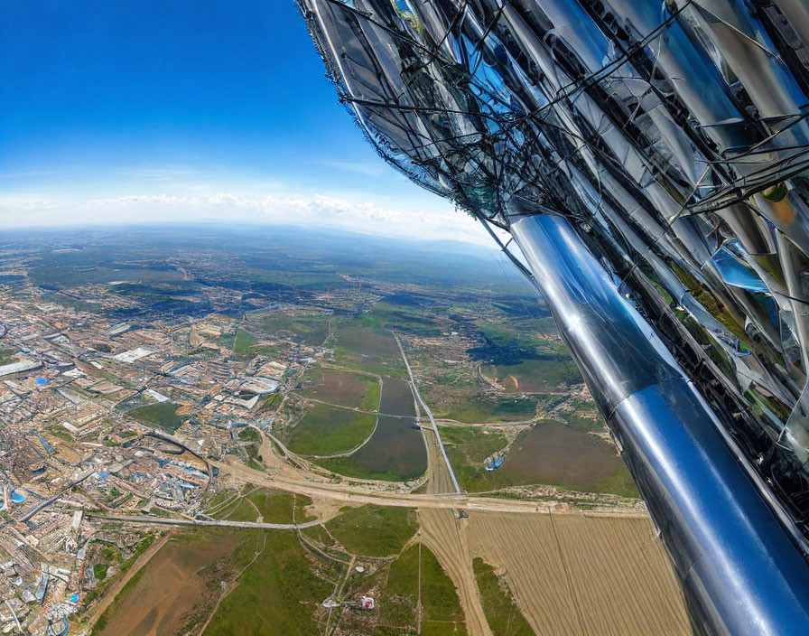 Cityscape, Green Fields, Roads, and Metallic Structure in Wide-Angle View