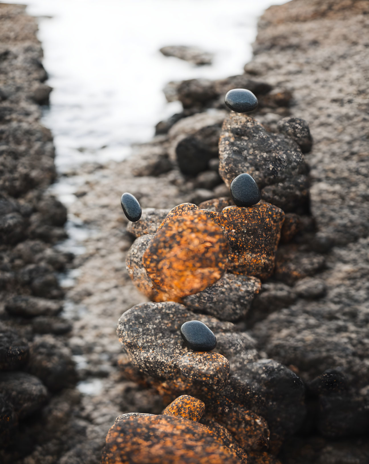 Balanced stacked stones on rugged coastal rock with pebbles