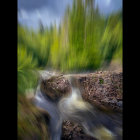 Tranquil painting of small waterfall over rocks surrounded by lush greenery