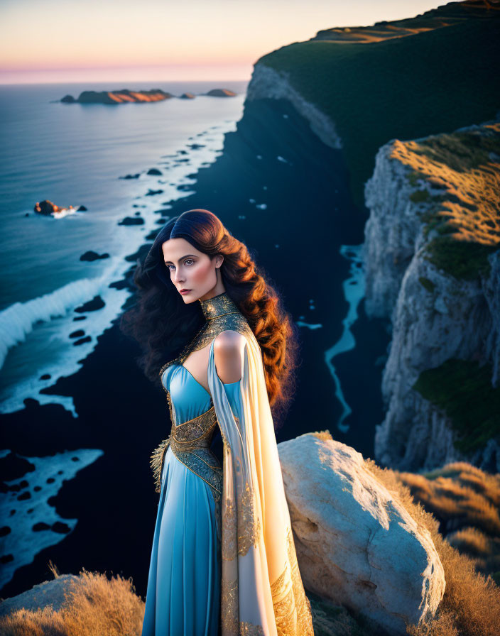 Woman in Blue and Gold Dress on Cliff at Sunset