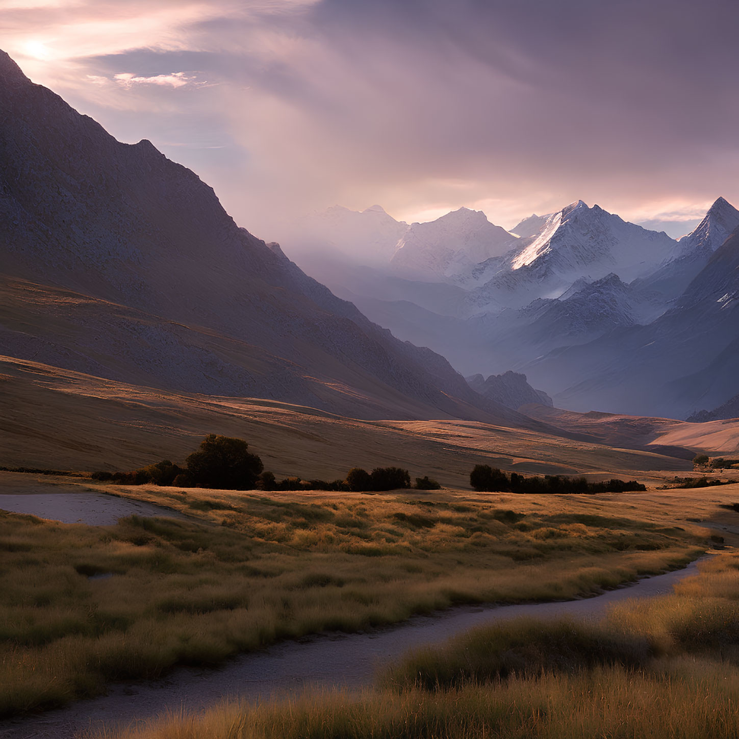 Majestic mountains and winding river in grassy valley at sunrise or sunset