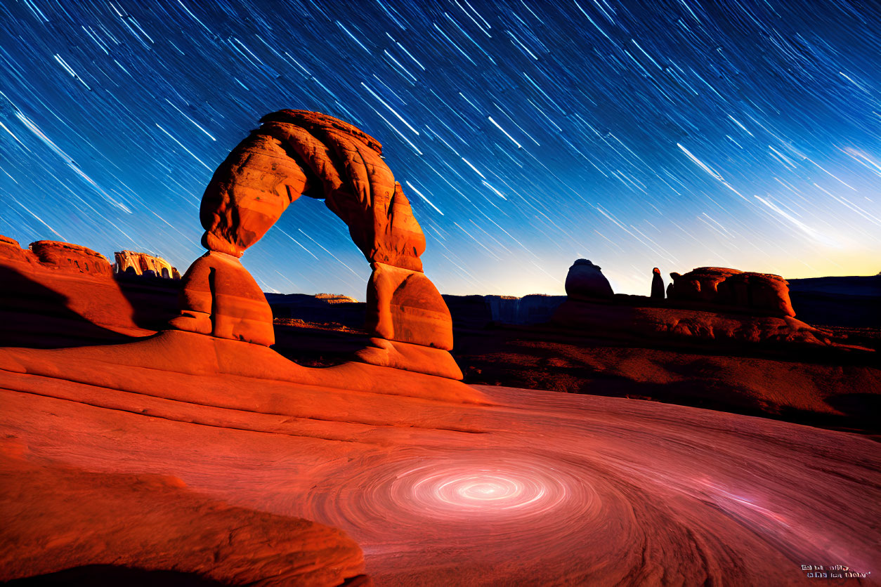 Long-exposure photo of star trails above Delicate Arch with vortex effect