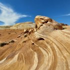 Astronaut on alien desert landscape with red rocks and multiple celestial bodies