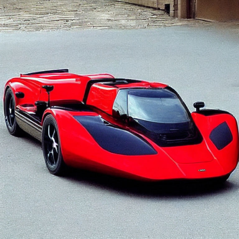 Red and Black Low-Profile Sports Car on Stone-Paved Surface