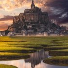 Grand castle on hill with dramatic sky and reflection in water.