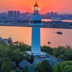 Coastal village with lighthouse at twilight: boats, houses, mountains under orange sky