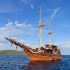 Sailboat painting with red hull on serene blue water