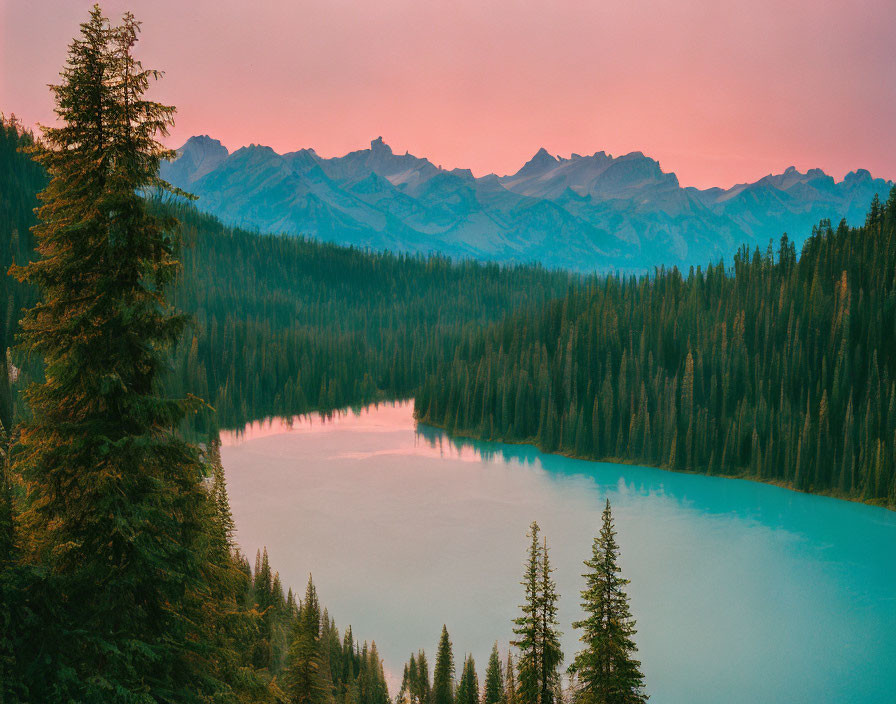 Tranquil lake at sunset with forest and mountain views