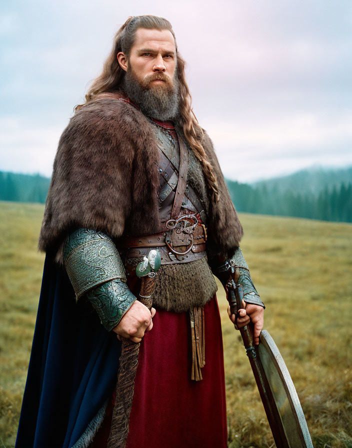 Bearded man in medieval warrior attire with sword in field