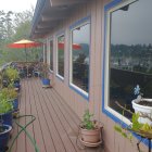 Tranquil balcony with intricate patterns, potted plants, and forested hill view