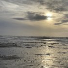 Scenic sunset on rocky coastline with golden light and clouds